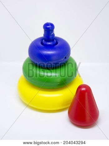 Cheap colored plastic pyramid toy on white background