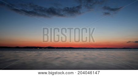 dark Cirrus clouds at sunset over the lake, South Ural, Uvildy