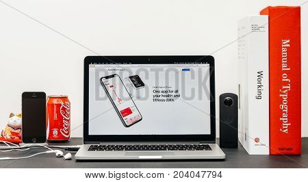 PARIS FRANCE - SEP 13 2017: Minimalist creative room table with Safari Browser open on MacBook Pro laptop at Apple Computers website with latest Apple Watch Series 3 with health app on iphone