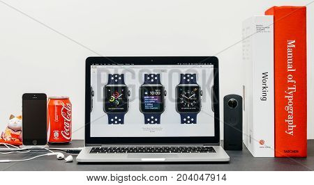 PARIS FRANCE - SEP 3 2017: Minimalist creative room table with Safari Browser on MacPook Pro laptop at Apple Computers website with latest Apple Watch Series 3 with selction of apple watc face band