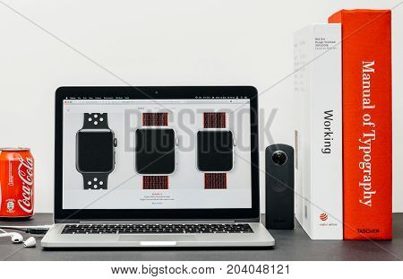 PARIS FRANCE - SEP 13 2017: Minimalist creative room table with Safari Browser open on MacBook Pro laptop at Apple Computers website with latest Apple Watch Series 3 with selction of apple watc face band