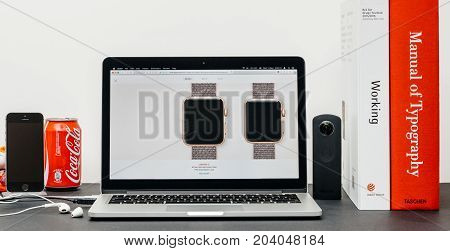 PARIS FRANCE - SEP 13 2017: Minimalist creative room table with Safari Browser open on MacBook Pro laptop at Apple Computers website with latest Apple Watch Series 3 with selction of apple watc face band