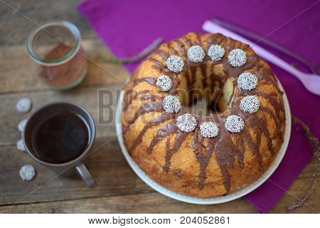 Bundt Cake with Chocolate Fudge Glaze and Chocolate nonpareils with colorful sprinkles on top.