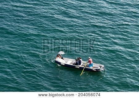 Cetara Italy - 02 August 2017: A newly married couple in rowing boat with the staff of photographers in Amalfi Coast