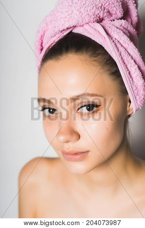 Portrait of a beautiful girl with a towel on her head. Clean skin