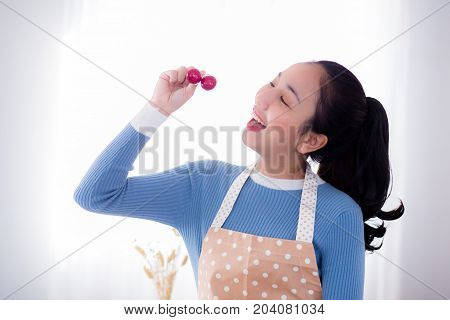 young woman eats fresh grapes in kitchen at home.