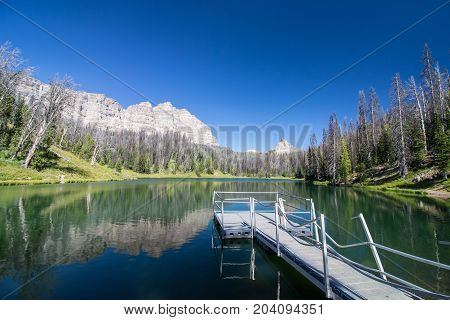 A pristine alpine lake in Wyoming with a small pier.