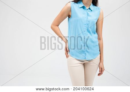 Low back pain woman plainclothes on a white wall