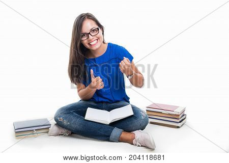 Student Sitting Making Winner Gesture With Books Around