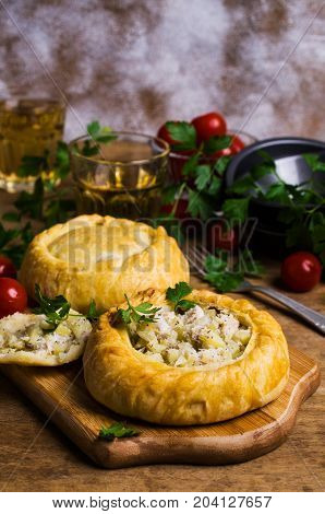 Round meat pie with vegetables and spices on a wooden background. Selective focus.