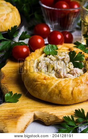 Round meat pie with vegetables and spices on a wooden background. Selective focus.