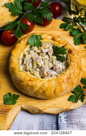 Round meat pie with vegetables and spices on a wooden background. Selective focus.