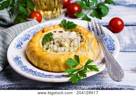 Round meat pie with vegetables and spices on a wooden background. Selective focus.