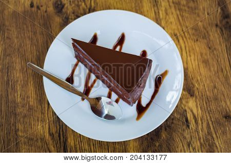 Delicious chocolate cake with spoon on white plate
