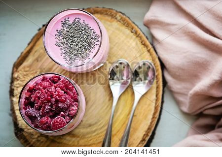 Chia and frozen raspberies cottage cheese breakfast in two small transparent glasses
