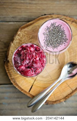 Chia and frozen raspberies cottage cheese breakfast in two small transparent glasses