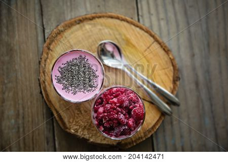 Chia and frozen raspberies cottage cheese breakfast in two small transparent glasses