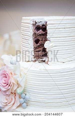 White wedding cake sliced open with cholate and black cherry filling