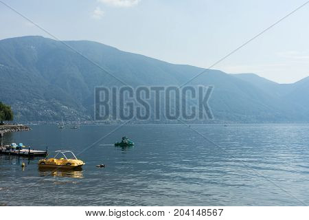 Pedalo Boat on lago maggiore lake in switzerland with moutnain view