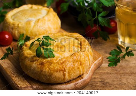Round meat pie with vegetables and spices on a wooden background. Selective focus.