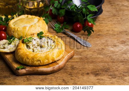 Round meat pie with vegetables and spices on a wooden background. Selective focus.
