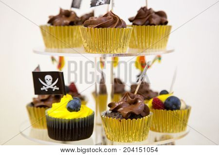 Cupcakes on stand in yellow and black colors pirate theme for kids birthday party