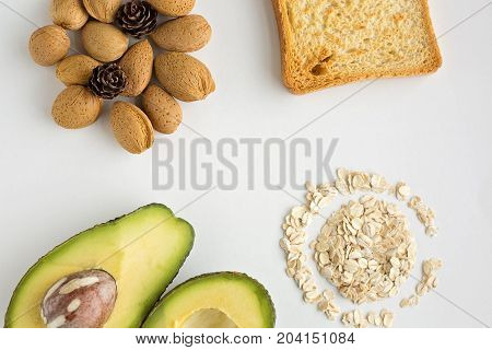 Sliced avocado oats toast and whole almonds view from above white background breakfast