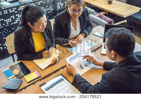 Business consultants is checking and analysis sales figures to plan business strategies with co-worker.