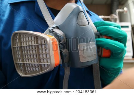 Multi-purpose respirator half mask for toxic gas protection.The man prepare to wear Multi-purpose respirator half mask.
