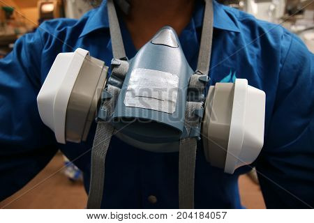 Multi-purpose respirator half mask for toxic gas protection.The man prepare to wear Multi-purpose respirator half mask.