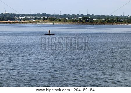A man navigating a canoe on the Patapsco River.
