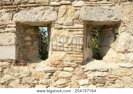 Narrow vertical apertures on historical walls in the medieval city of Girona Catalonia Spain