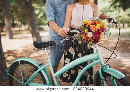 Horizontal close-up image of body parts cute girl and boy. with bright gift, standing in the forest with bicycle. Lifestyle concept.