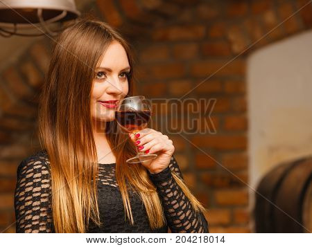 Woman Tasting Wine In Rural Cottage Interior