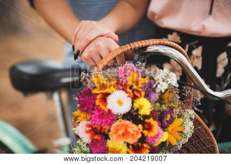 Close-up image of body parts cute girl and boy. with bright gift, standing in the forest with bicycle. Lifestyle concept.
