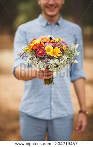 Close-up photo of body parts cute boy. with bright gift, standing in the forest. Lifestyle concept.