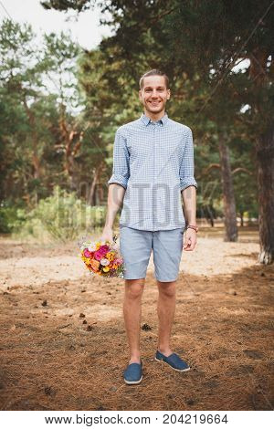 Full length photo of cute boy. with bright gift, standing in the forest. Lifestyle concept.