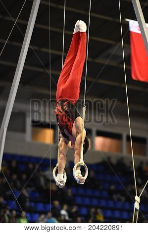 Male Gymnast Performing On Stationary Gymnastic Rings