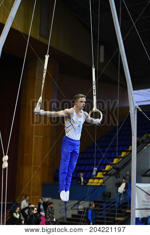 Male Gymnast Performing On Stationary Gymnastic Rings