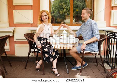 Young Couple Talking at Coffee Shop on a date. Loving couple having fun at a restaurant.
