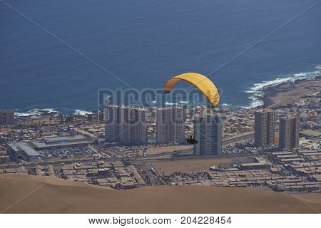 Iquique, Tarapaca Region, Chile - August 20, 2017: Paraglider over the coastal city of Iquique on the northern coast of Chile.