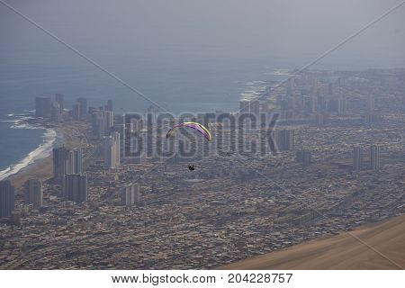 Iquique, Tarapaca Region, Chile - August 20, 2017: Paraglider over the coastal city of Iquique on the northern coast of Chile.