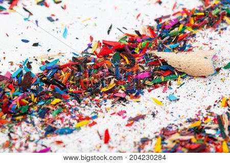 Small shavings from color pencils on grey background