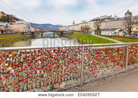 Salzburg, Austria - December 25, 2016: Historic city of Salzburg with love padlocks bridge and Hohensalzburg Festung castle across Salzach river, Austria