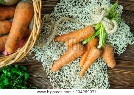 Top View Bunch Of Fresh Organic Dirty Carrots And Oher Purchased Products From Farm Market On The Wo