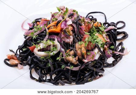 Black spaghetti with seafood and vegetables .