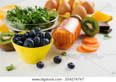 Healthy food good for eyes over white table. Productis fos excellent vision. Space for text