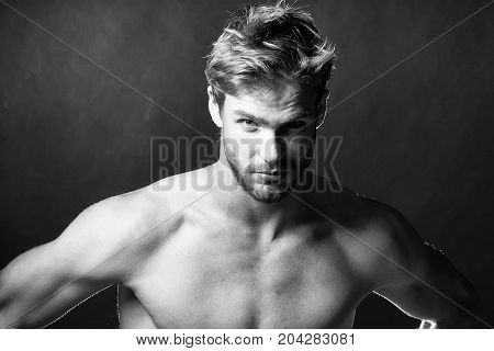 Closeup view portrait of one handsome young muscular naked sexy macho man with short hair bare chest abd beautiful body standing in studio on black backdrop horizontal picture