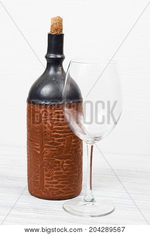 Black bottle of wine and wneglass on the background of the canvas
