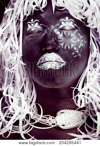 creative makeup like Ethiopian mask, white pattern on black face close up, halloween horror, fashion style print